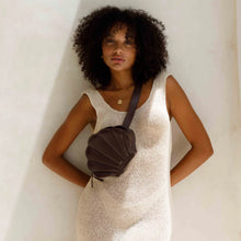 Load image into Gallery viewer, Woman in a white dress holding a brown bag against a neutral background