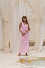 Load image into Gallery viewer, Woman in a pink maxi skirt and tank top standing in a decorative indoor setting with columns and a pool.
