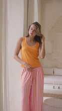 Load and play video in Gallery viewer, woman wearing orange tank top and striped pants