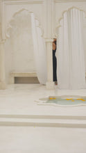 Load and play video in Gallery viewer, Woman wearing a black maxi skirt and tank top in a marble courtyard setting.