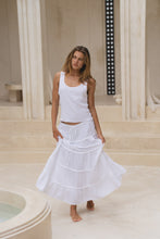 Load image into Gallery viewer, Woman wearing a white tank top and skirt in a classical architectural setting
