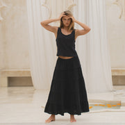 Woman wearing a black tiered skirt and tank top in a marble interior setting