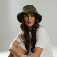 Load image into Gallery viewer, Woman wearing a white t-shirt, denim shorts, and a green bucket hat on a light background
