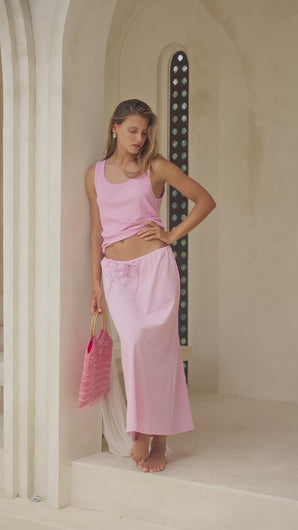 woman wearing a pink tank top and skirt