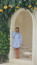 Load and play video in Gallery viewer, Woman in a blue and white striped shirt dress standing in a decorative archway.
