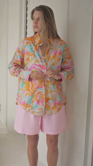 Woman wearing a colorful patterned shirt in a bright room