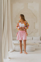 Load and play video in Gallery viewer, Woman wearing a colorful patterned shirt in a bright room twirling.
