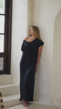 Load and play video in Gallery viewer, Woman in a black maxi dress standing  in a bright room.
