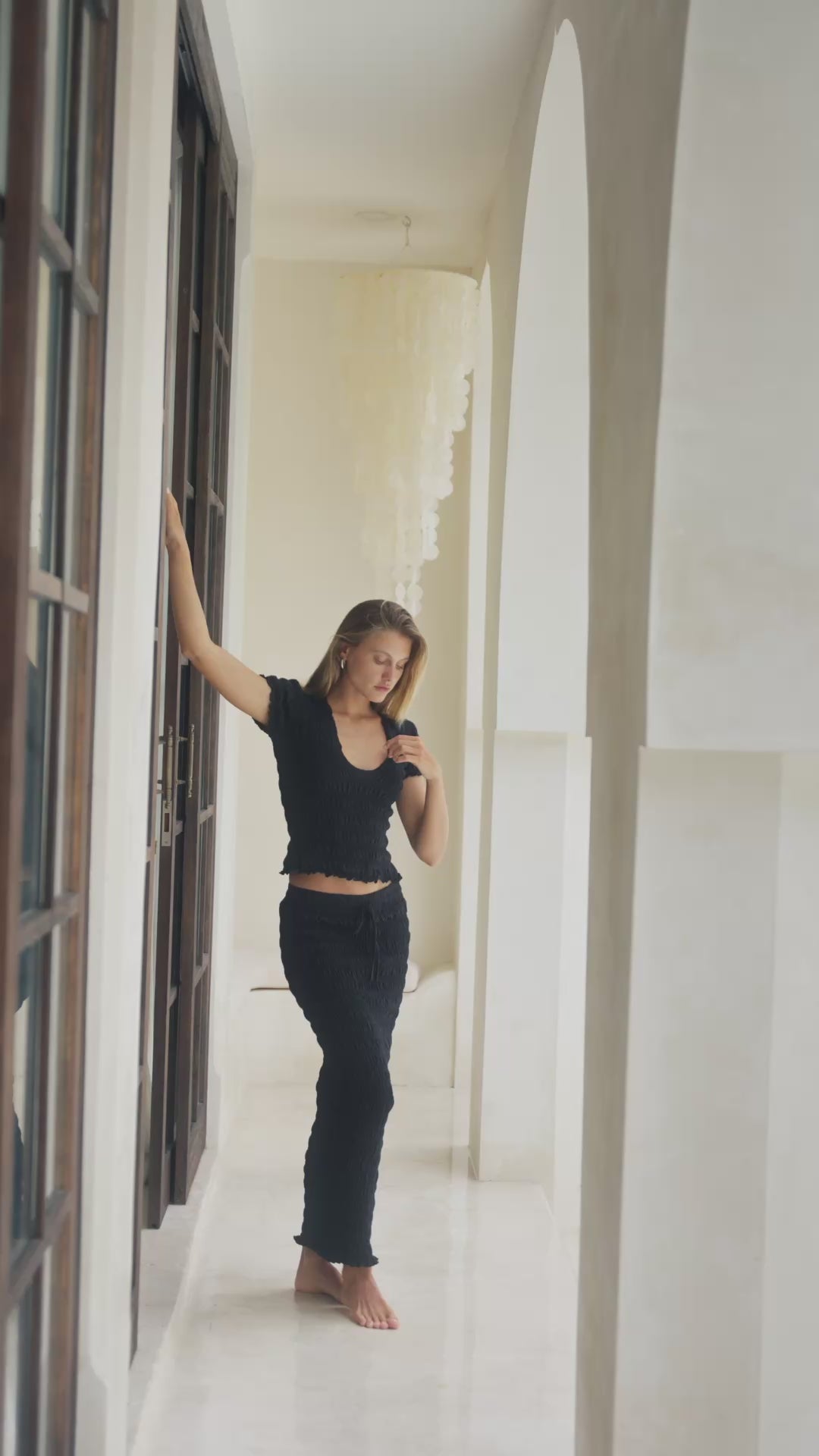 Load video: woman in black shirred top and shirred maxi skirt