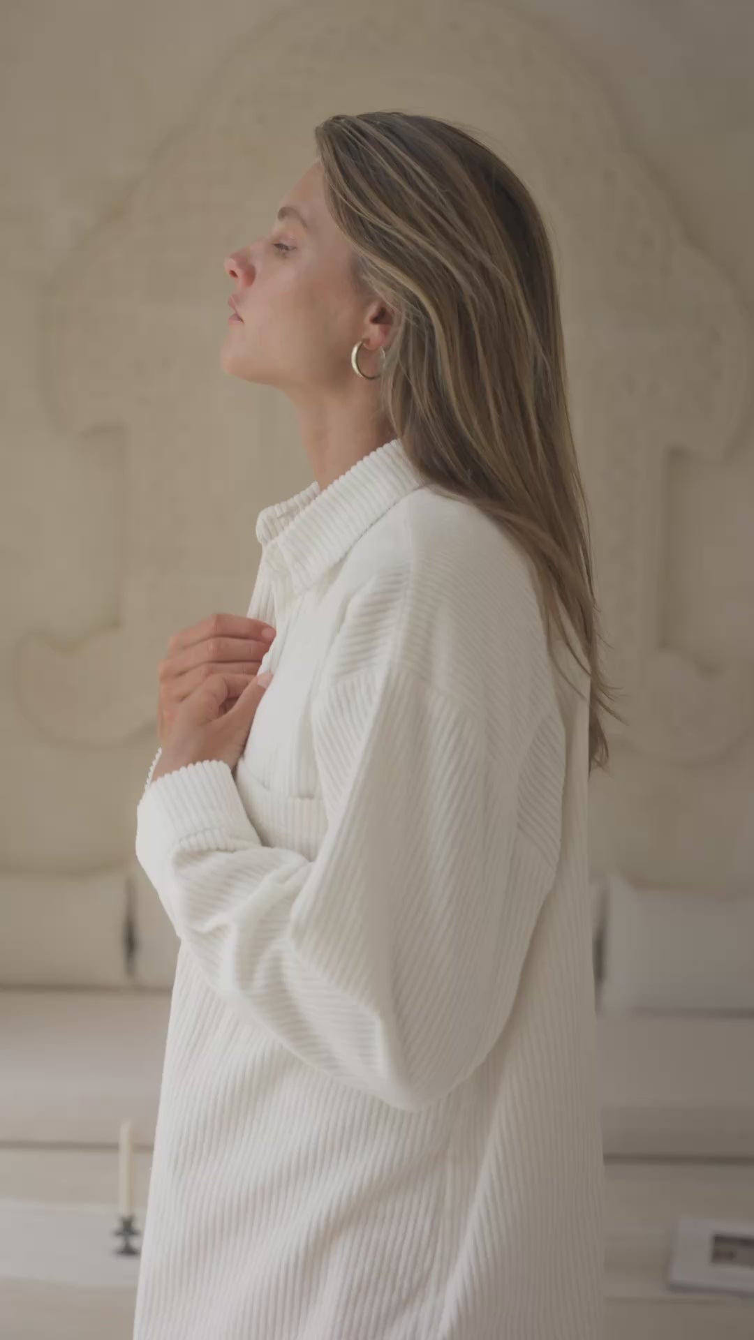 Load video: Woman wearing a white corduroy jacket and pink shorts against a neutral background