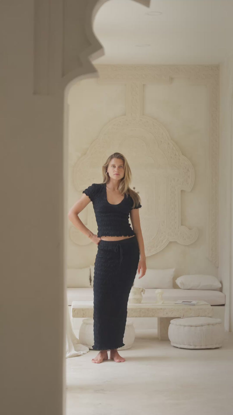 woman in black shirred top and shirred maxi skirt